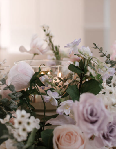 Blush, lilac and white blooms around candle bowl