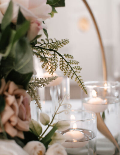 Fern foliage beside floating candles in glass cylinders