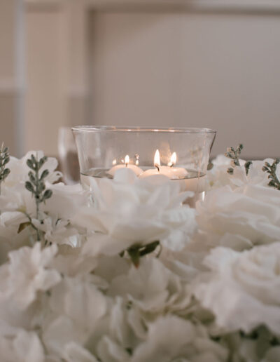Floating candles surrounded by white hydrangea and roses