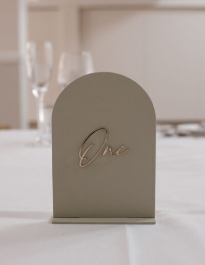 Sage green arched acrylic table sign with rose gold script