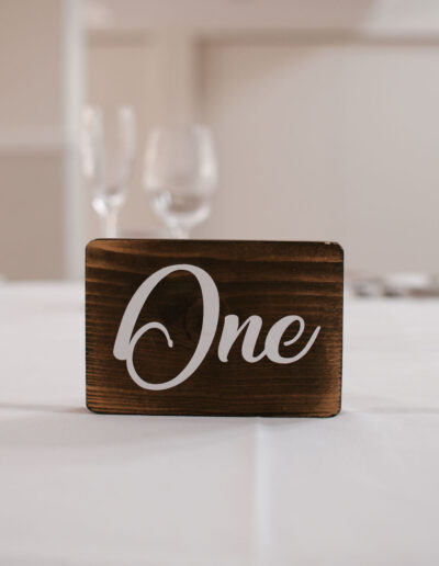 Stained wood block table sign with white script