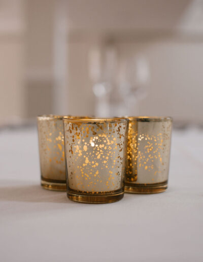 Three gold mercury glass votives with tealights