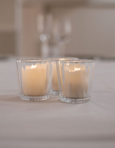 Three ribbed clear glass votives with candles