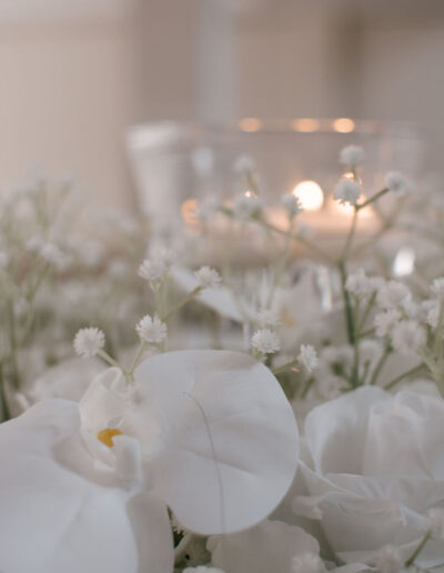 White orchid and gypsophila beside floating candles