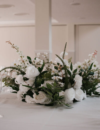 White rose and foliage centrepiece with wildflower sprigs