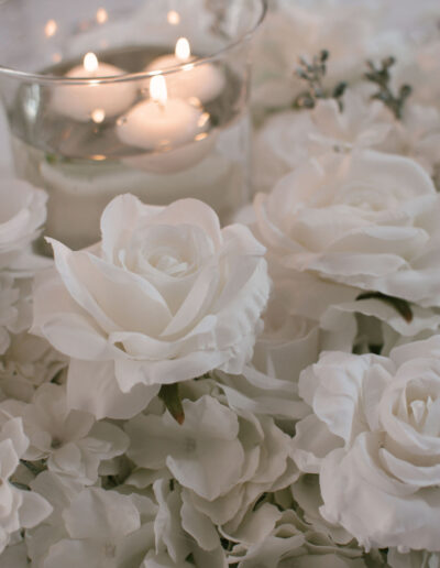 White roses and hydrangea beside floating candles